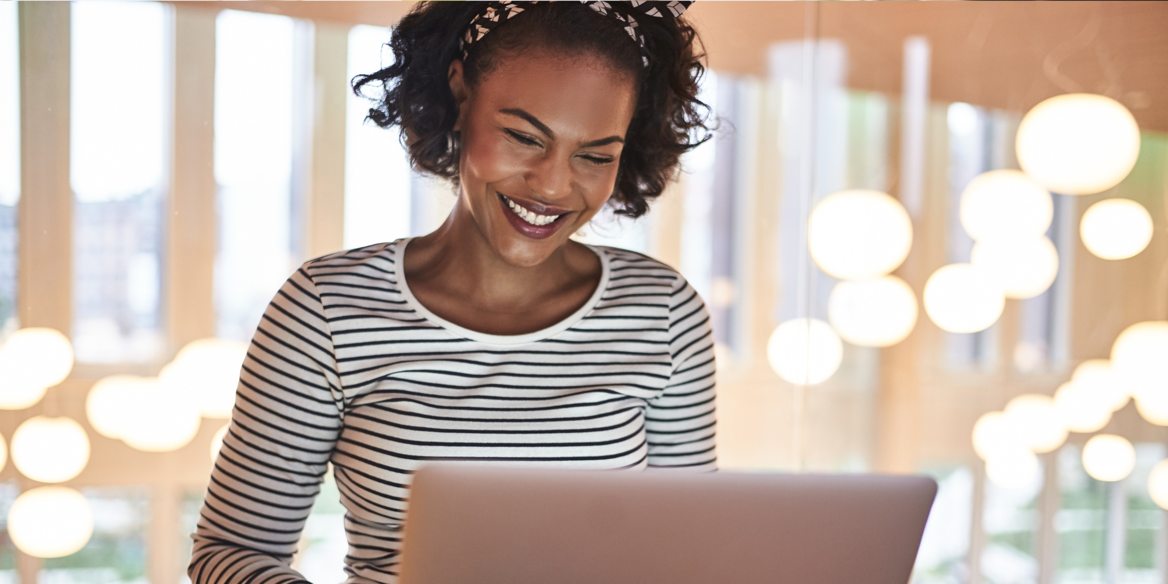 a student smiling at a laptop