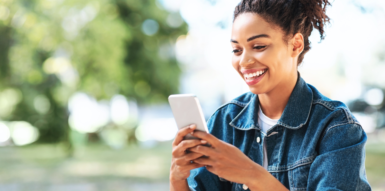 a student smiling at their cell phone