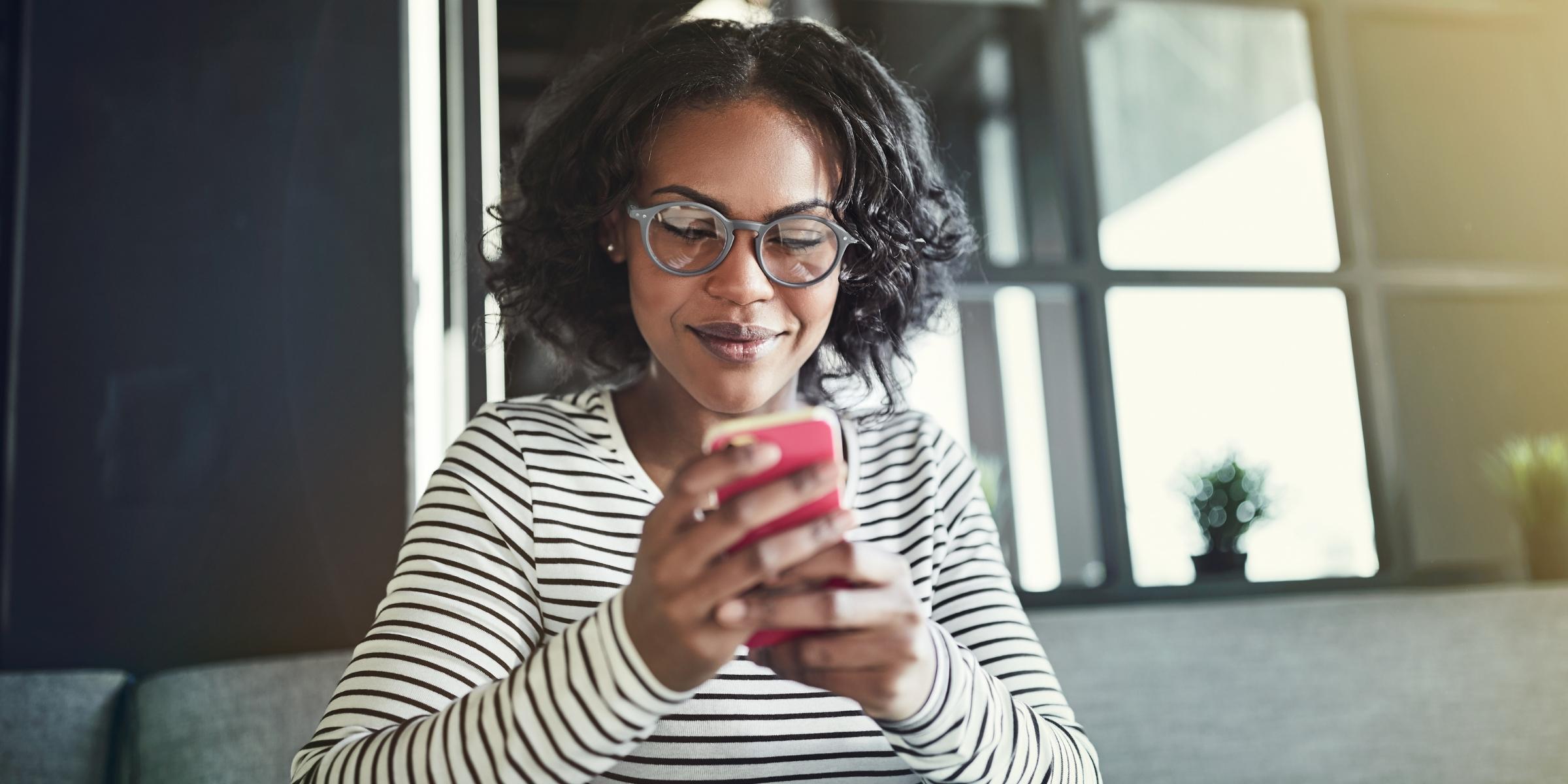 a person smiling at their cell phone