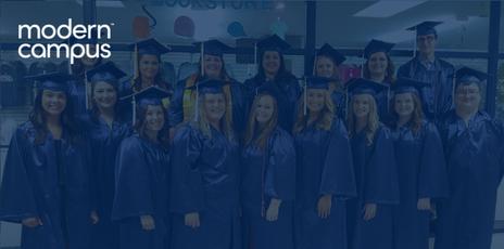 a dozen students smiling in blue graduation caps and gowns